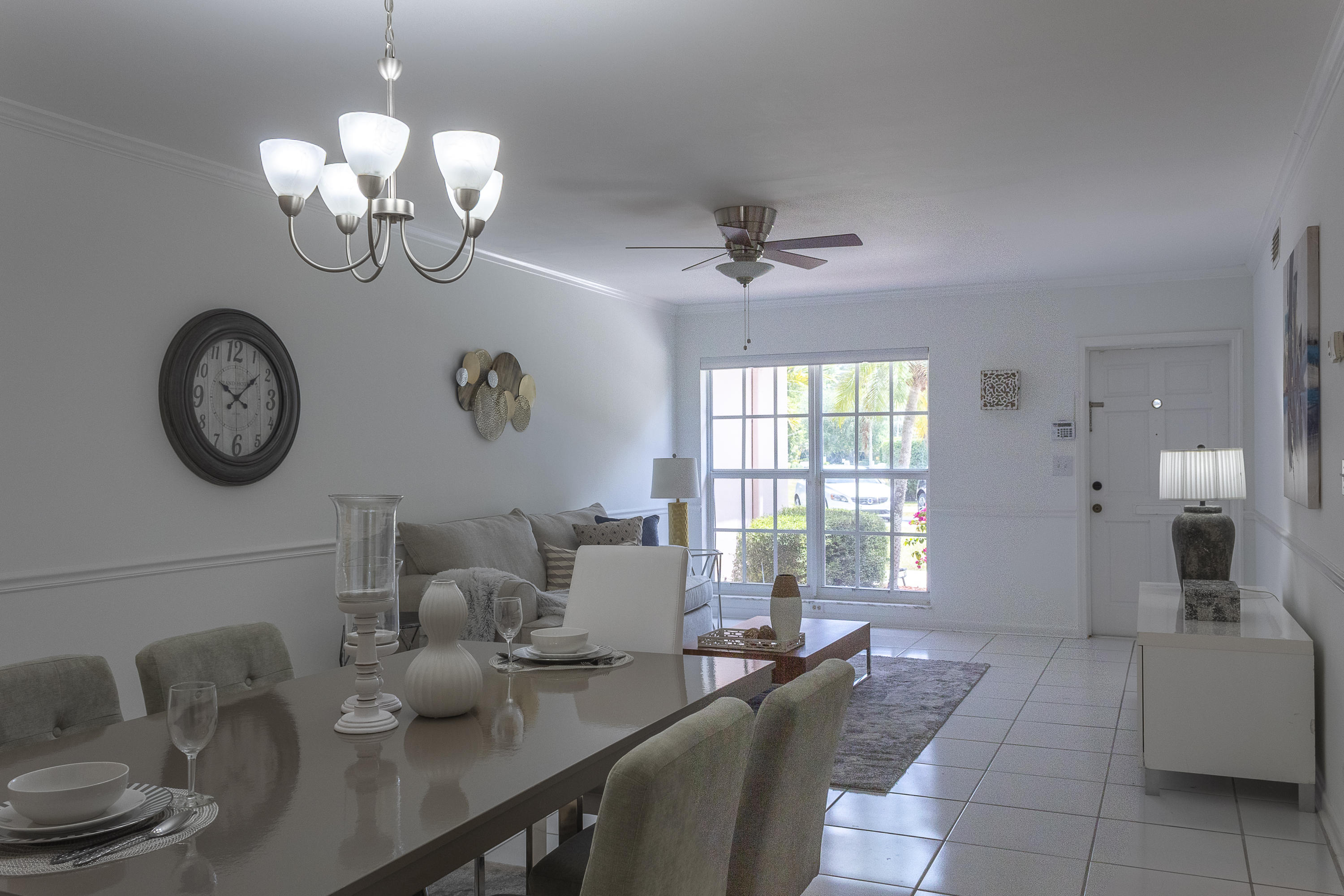 770 East Camino Real, Unit 60 Boca Raton, FL 33432 - Photo 9 of 40 a dining room with wooden floor a chandelier a wooden table and chairs