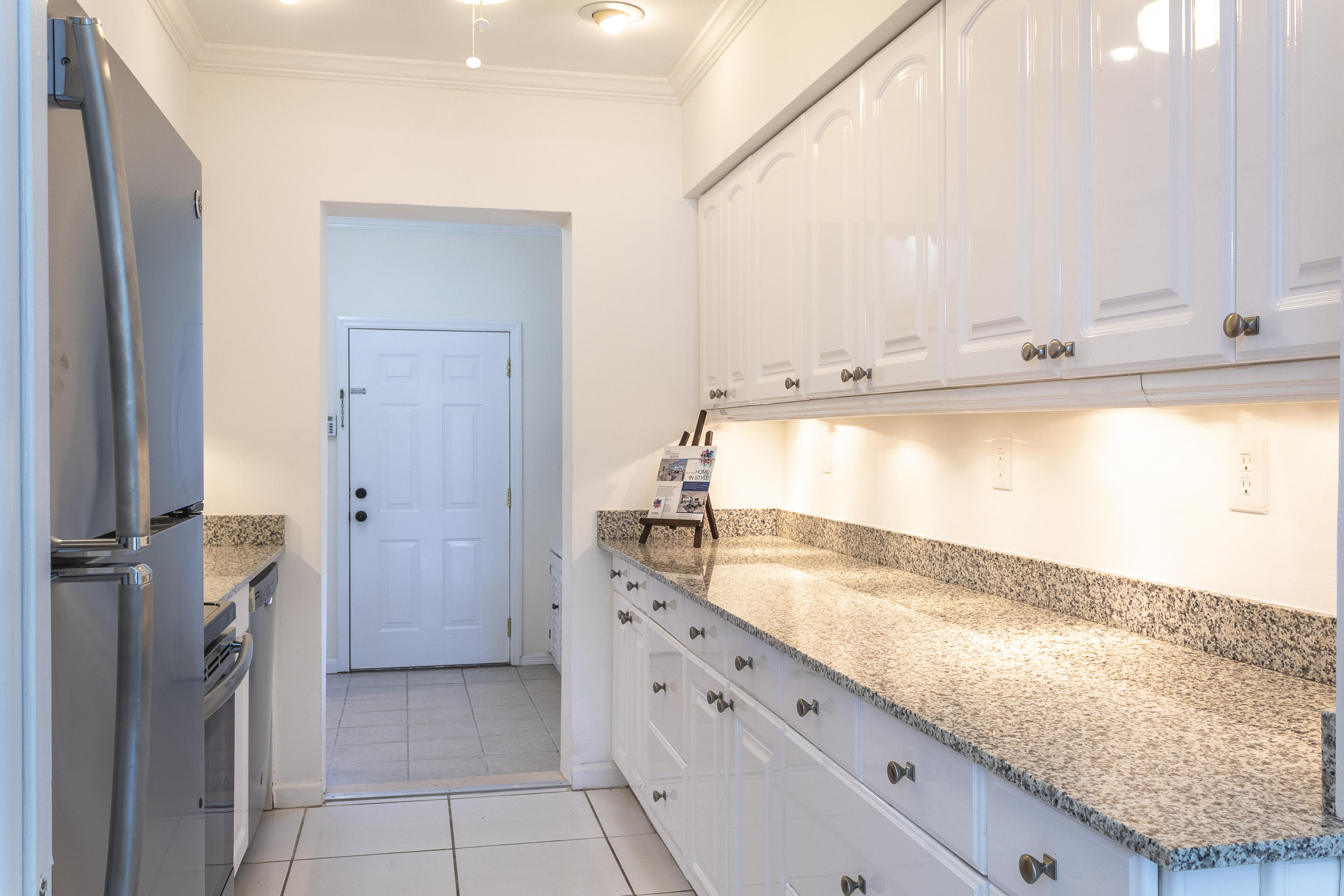 770 East Camino Real, Unit 60 Boca Raton, FL 33432 - Photo 10 of 40 a view of a kitchen with kitchen island a sink a refrigerator and a window