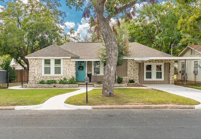 a white house with a large pool in front of a house