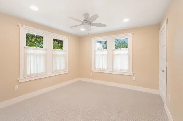 an empty room with windows and closet