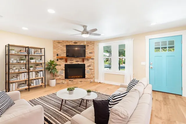 a living room with furniture a flat screen tv and a fireplace