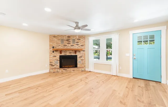 a view of an empty room with a fireplace and a window
