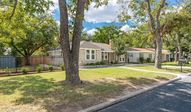 a front view of a house with swimming pool and trees
