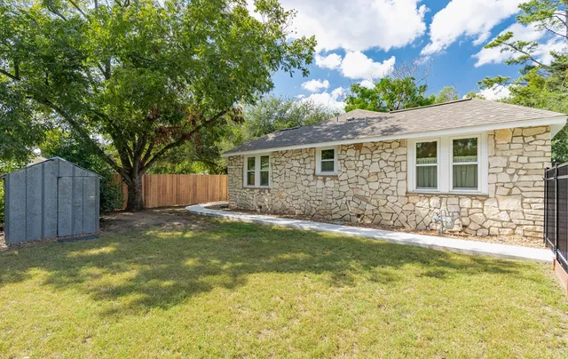 a backyard of a house with table and chairs
