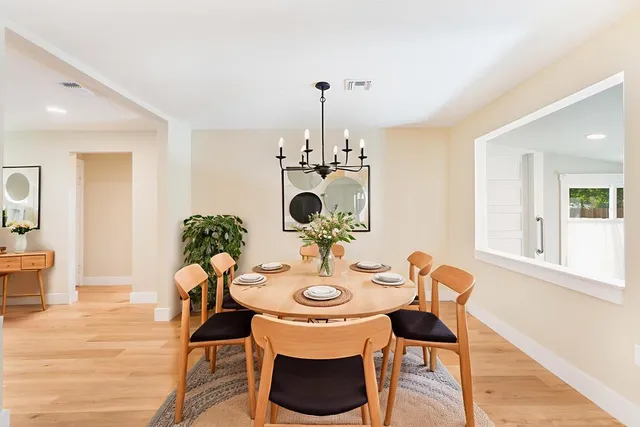 a dining room with furniture a chandelier and wooden floor