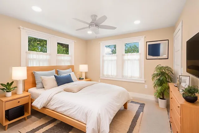 a bedroom with bed and a large window