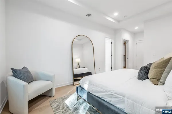 a bedroom with a bed a couch and a mirror
