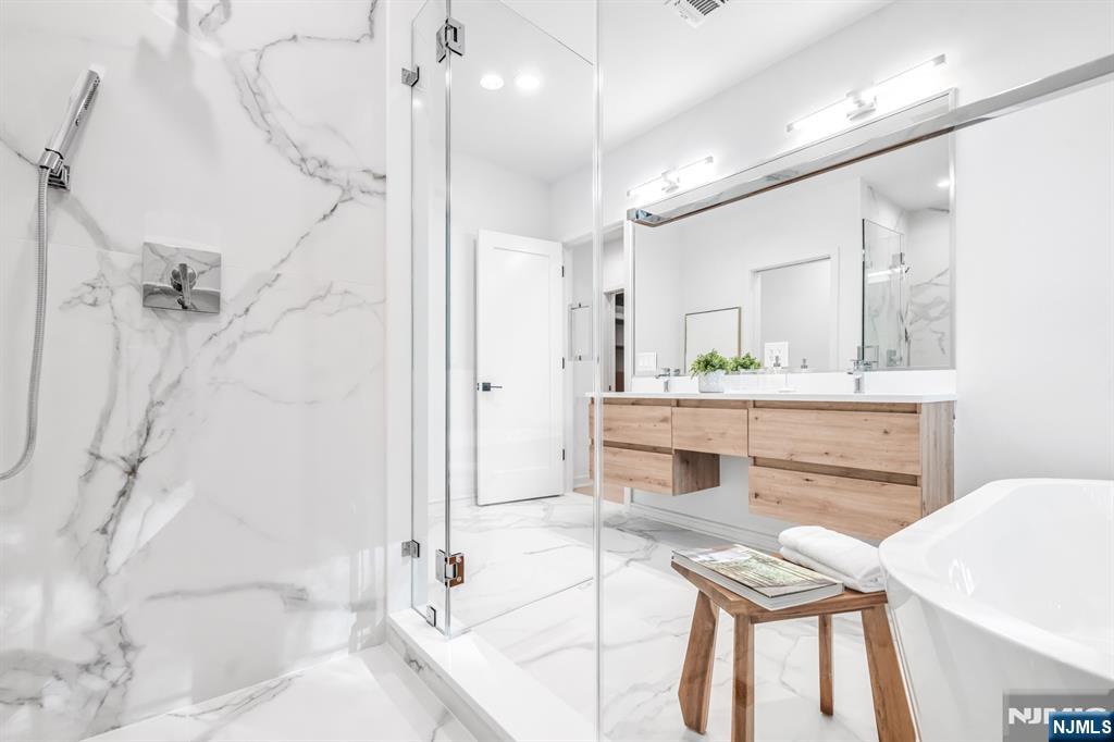 23 Fey Place Oradell, NJ 07649 - Photo 23 of 36 a spacious bathroom with a double vanity sink a mirror a bathtub and shower