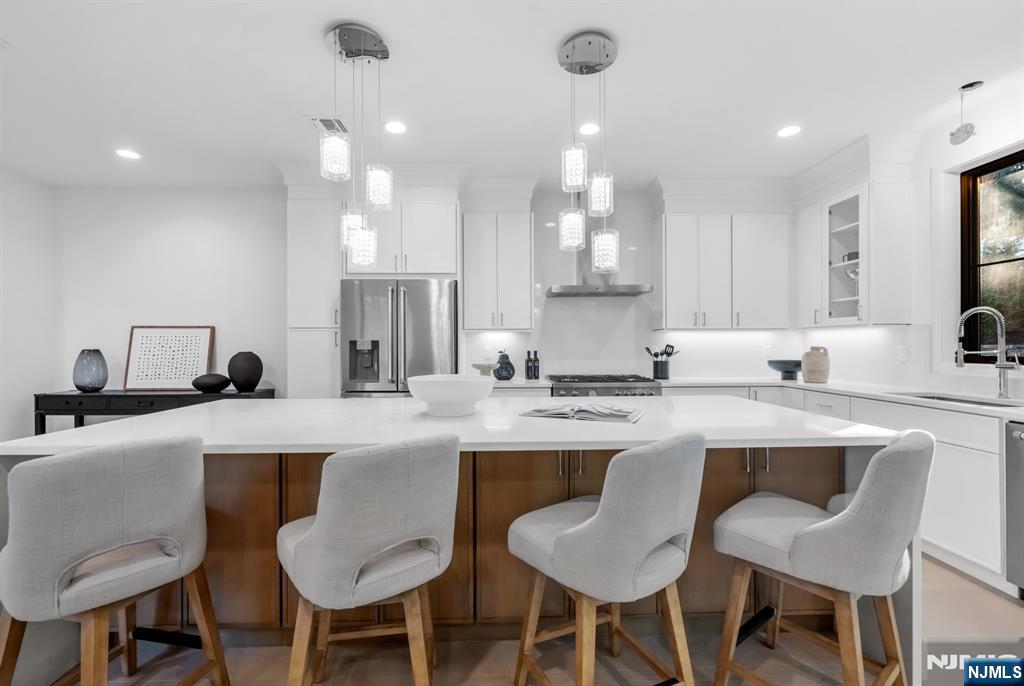 23 Fey Place Oradell, NJ 07649 - Photo 8 of 36 a kitchen with a dining table chairs sink and cabinets