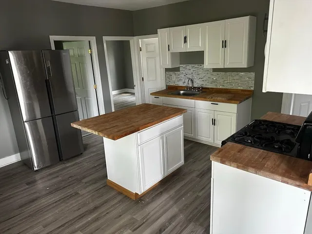 a kitchen with a appliances wooden floor and a sink