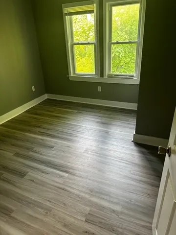 a view of room with window and wooden floor