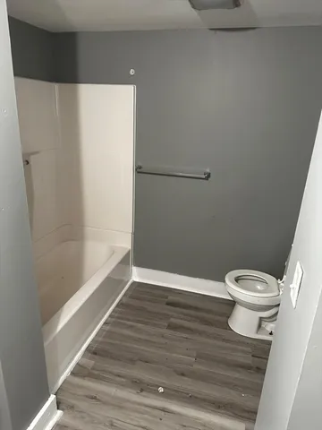 a white toilet sitting next to a bath tub