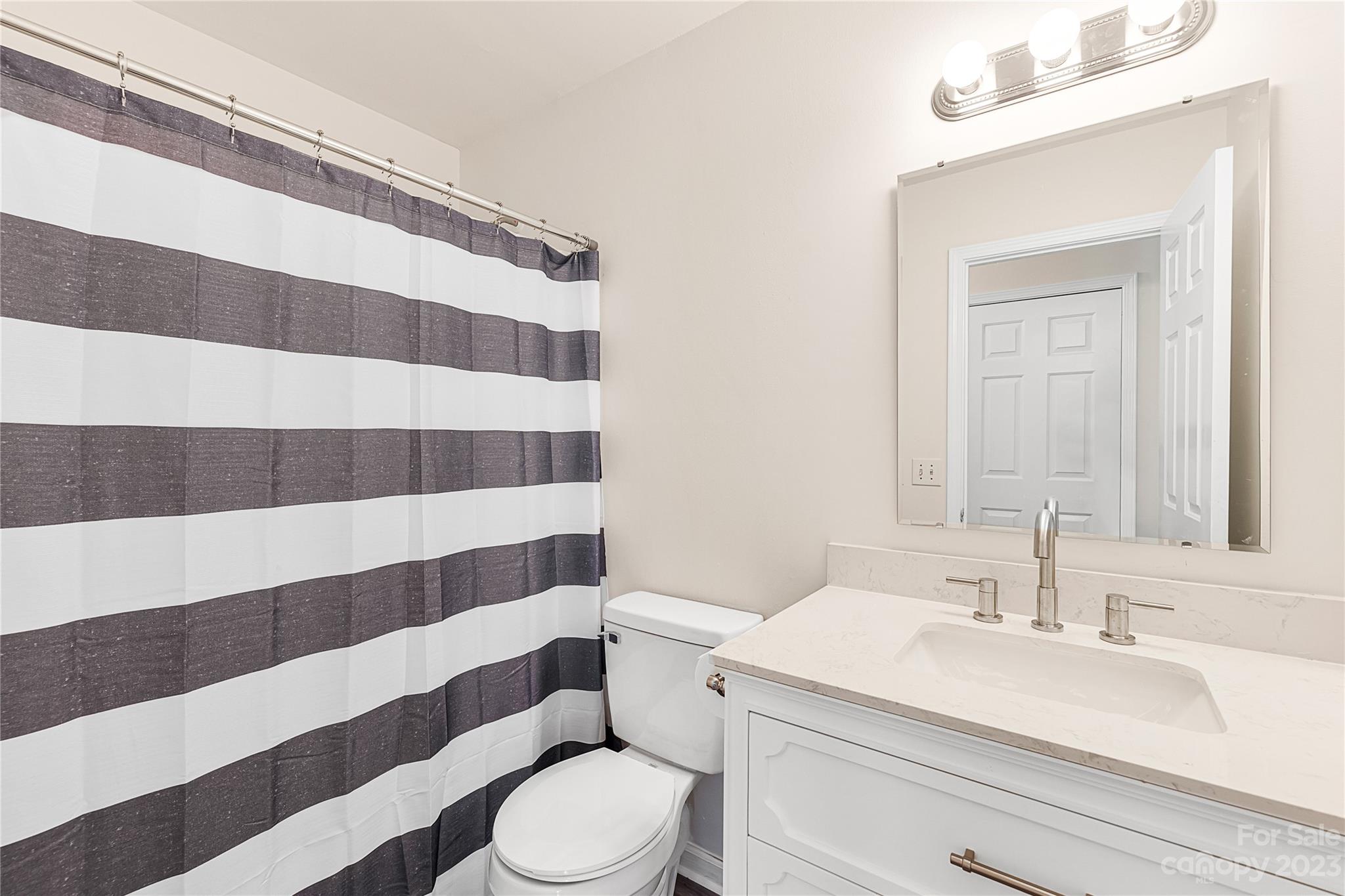 9504 Foggy Meadow Road Charlotte, NC 28269 - Photo 11 of 24 a bathroom with a sink a toilet a mirror and shower