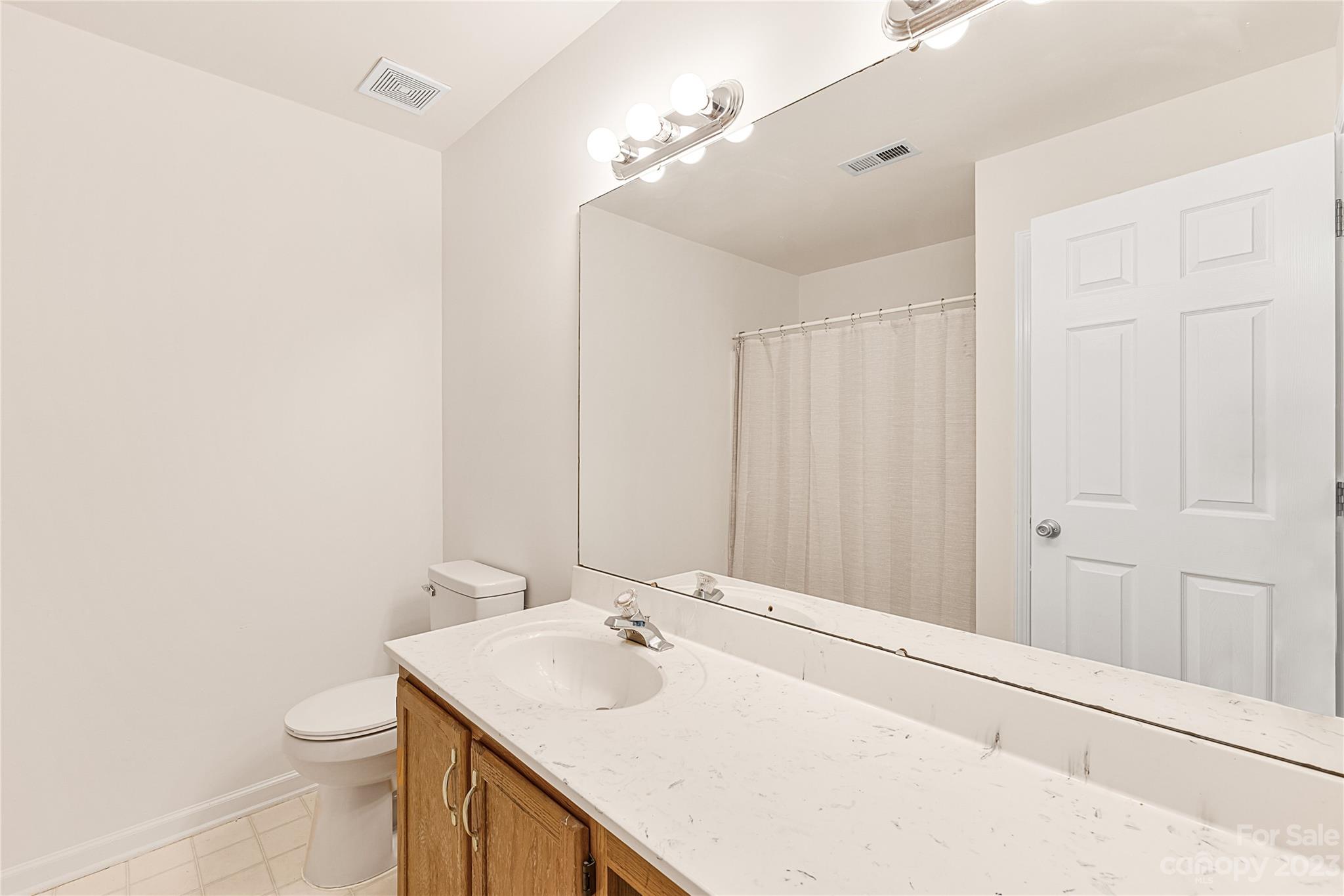 9504 Foggy Meadow Road Charlotte, NC 28269 - Photo 14 of 24 a bathroom with a sink a toilet and mirror