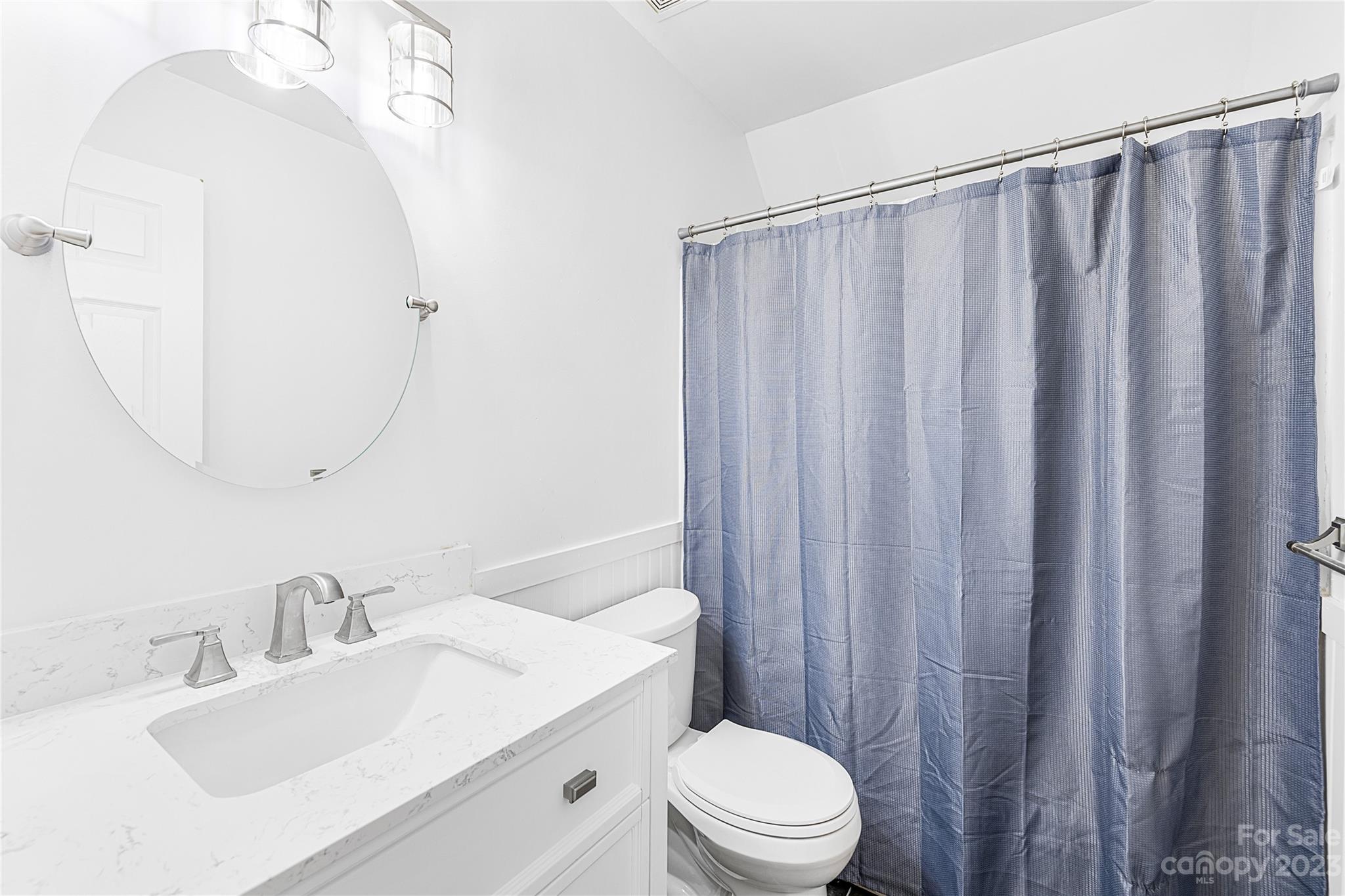 9504 Foggy Meadow Road Charlotte, NC 28269 - Photo 17 of 24 a bathroom with a sink a toilet and shower curtain