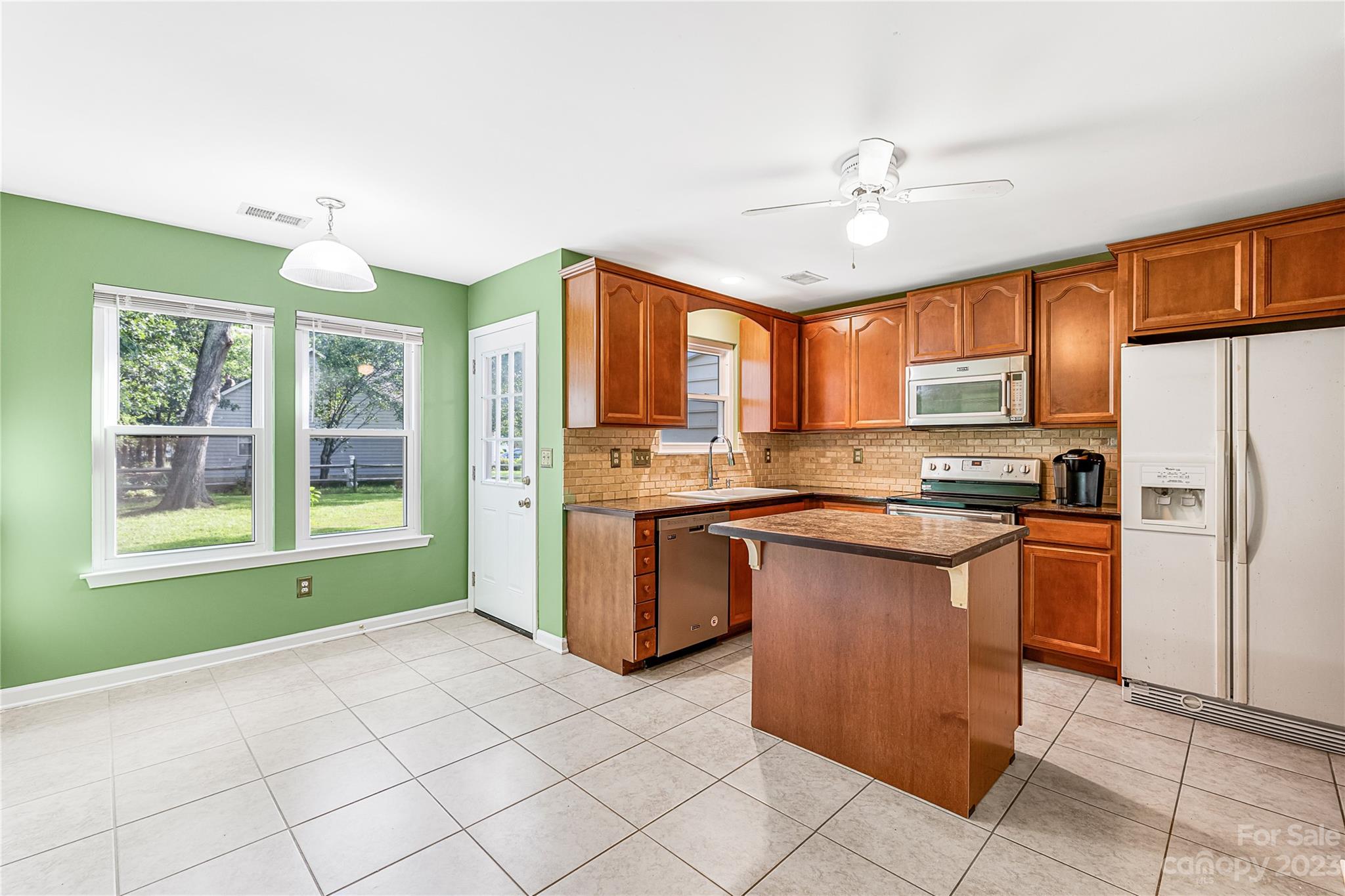 9504 Foggy Meadow Road Charlotte, NC 28269 - Photo 7 of 24 a kitchen with stainless steel appliances granite countertop a refrigerator a sink a stove top oven and a window