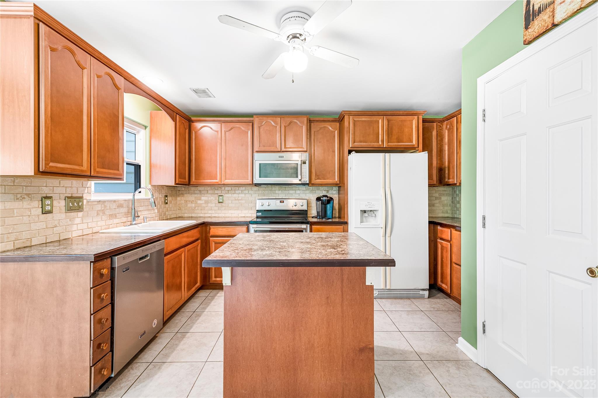 9504 Foggy Meadow Road Charlotte, NC 28269 - Photo 8 of 24 a kitchen with stainless steel appliances granite countertop a refrigerator a sink dishwasher a stove and white cabinets with wooden floor