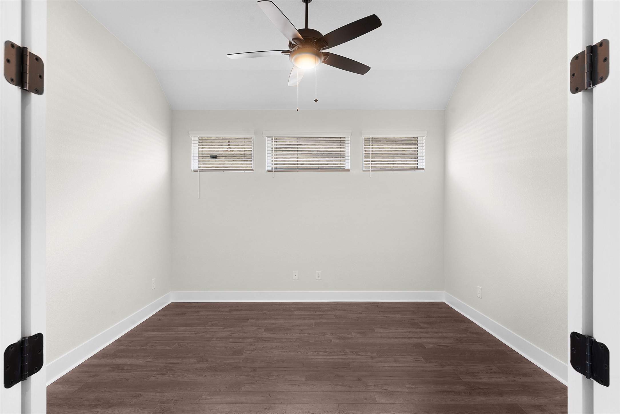 1121 Pansy Trail Georgetown, TX 78628 - Photo 5 of 25 Empty room with lofted ceiling, dark wood-style flooring, healthy amount of natural light, and a ceiling fan