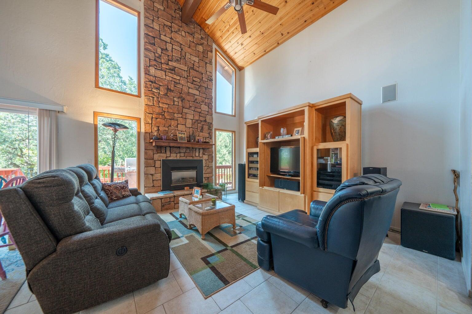 8846 Goldstone Lane Redding, CA 96001 - Photo 11 of 64 a living room with furniture a fireplace and a large window