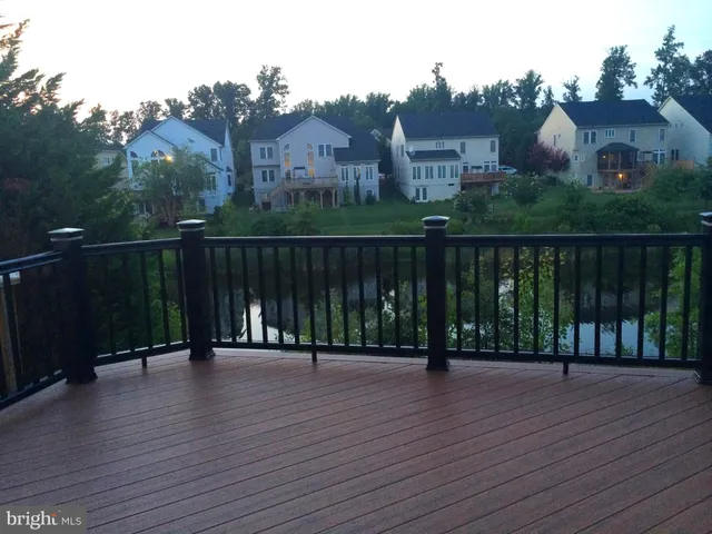 a patio with couches table and chairs with wooden floor and fence