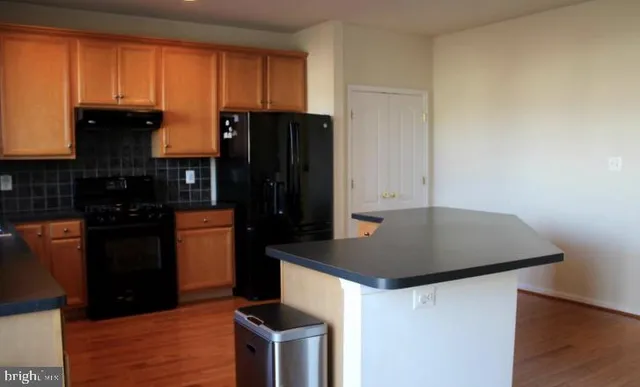 a kitchen with a refrigerator and a stove top oven