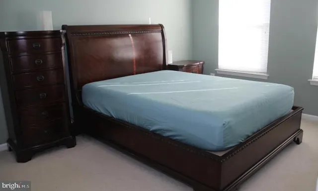 a bed sitting in a bedroom next to a window