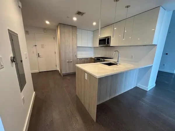 a kitchen with a sink and wooden floor