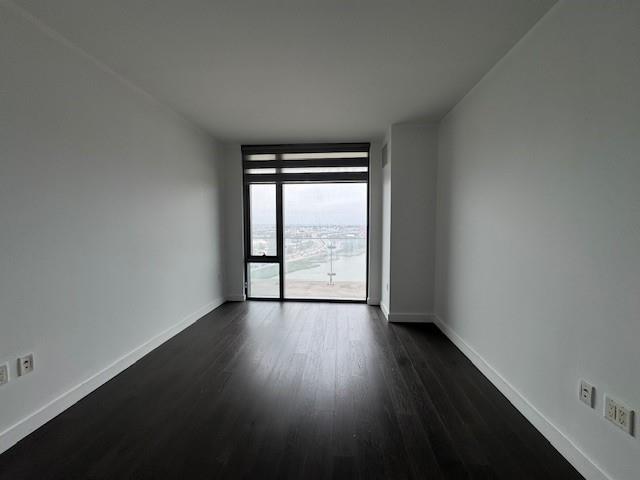 13105 40th Road, Unit 15E Queens, NY 11354 - Photo 6 of 15 an empty room with wooden floor and windows