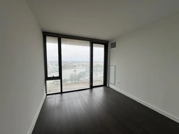 an empty room with windows and wooden floor