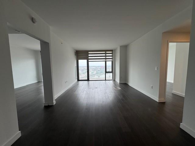 13105 40th Road, Unit 15E Queens, NY 11354 - Photo 9 of 15 an empty room with wooden floor and windows
