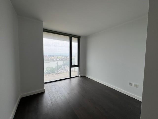 13105 40th Road, Unit 15E Queens, NY 11354 - Photo 10 of 15 an empty room with wooden floor and windows