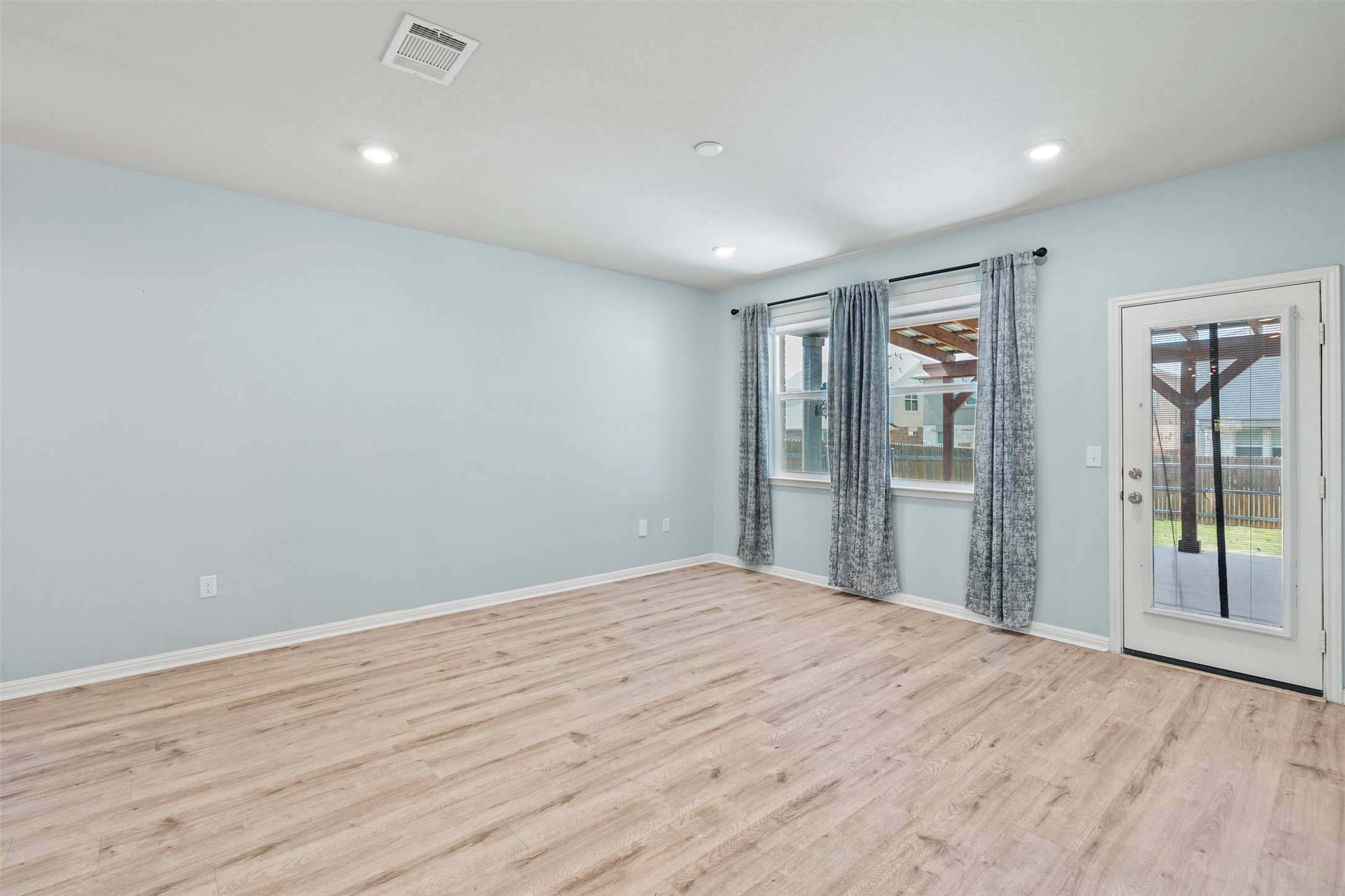 120 Ellinger Road Georgetown, TX 78626 - Photo 14 of 28 Open concept room featuring wood-finish flooring, recessed lighting, and light blue wall paint