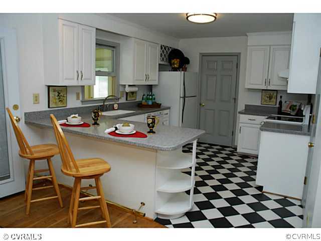 4211 Saratoga Road Richmond, VA 23235 - Photo 11 of 24 a kitchen with a sink a stove a refrigerator and cabinets