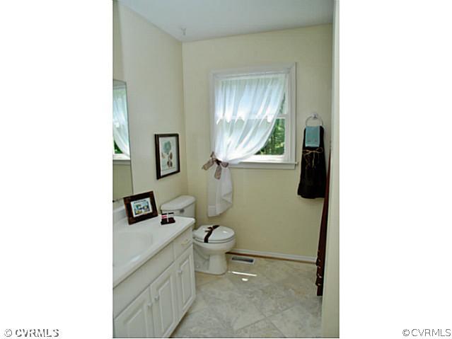 4211 Saratoga Road Richmond, VA 23235 - Photo 21 of 24 a bathroom with a toilet a sink and mirror