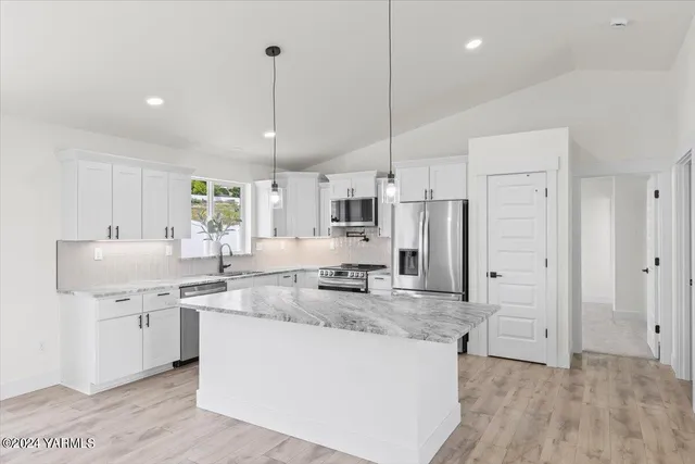 a kitchen with stainless steel appliances granite countertop a sink a stove and a refrigerator