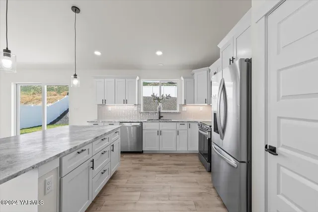 a kitchen with a sink refrigerator and cabinets