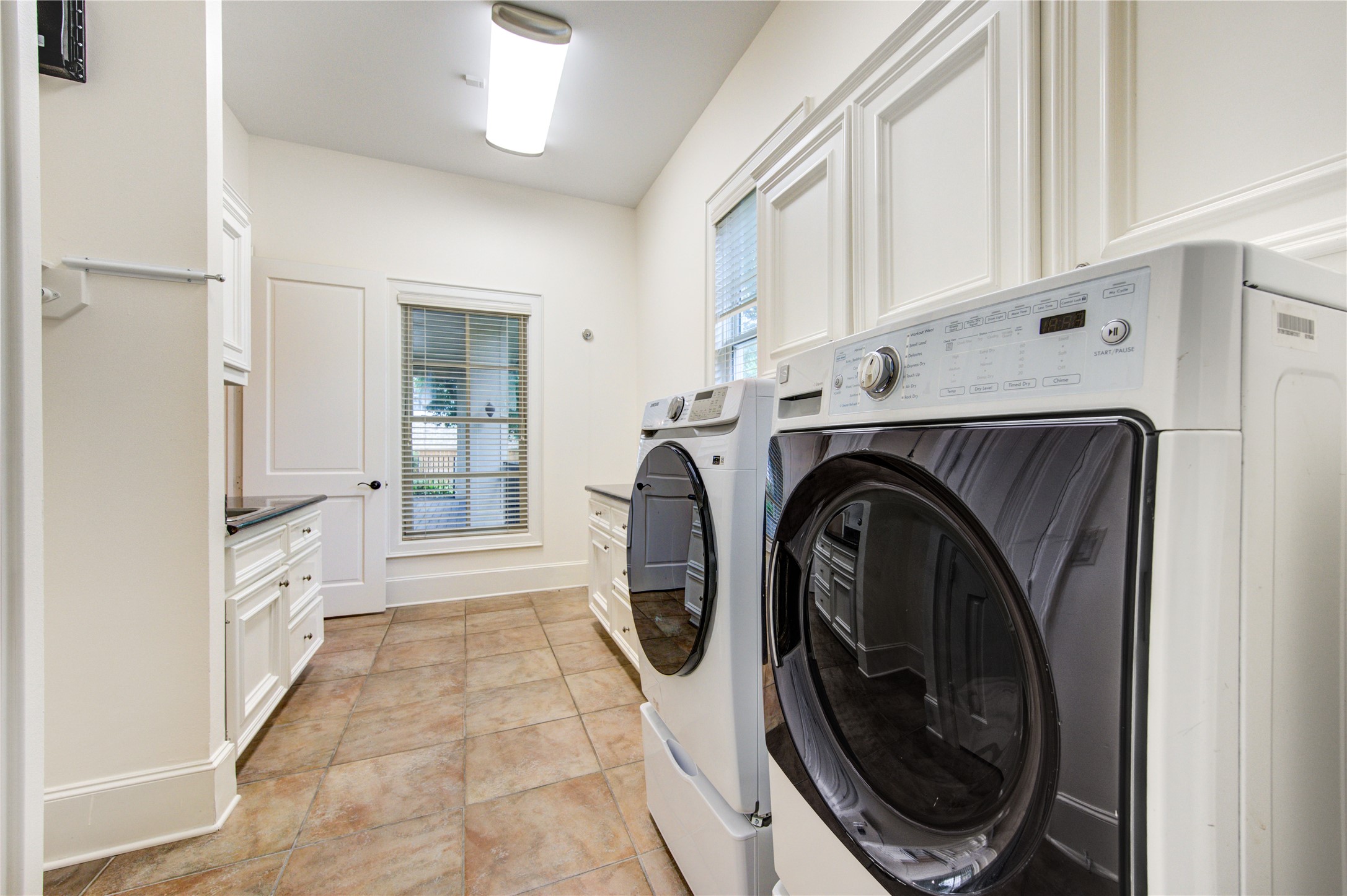 4615 Laurel Street Bellaire, TX 77401 - Photo 22 of 48 Oversized laundry room with sink, hanging area, and built-in closets and cabinets and counter space.