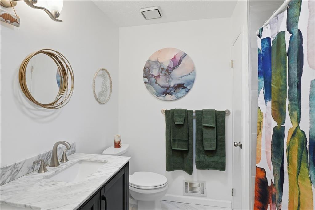 338 Arbour Way Suwanee, GA 30024 - Photo 15 of 32 a bathroom with a toilet a sink and a mirror