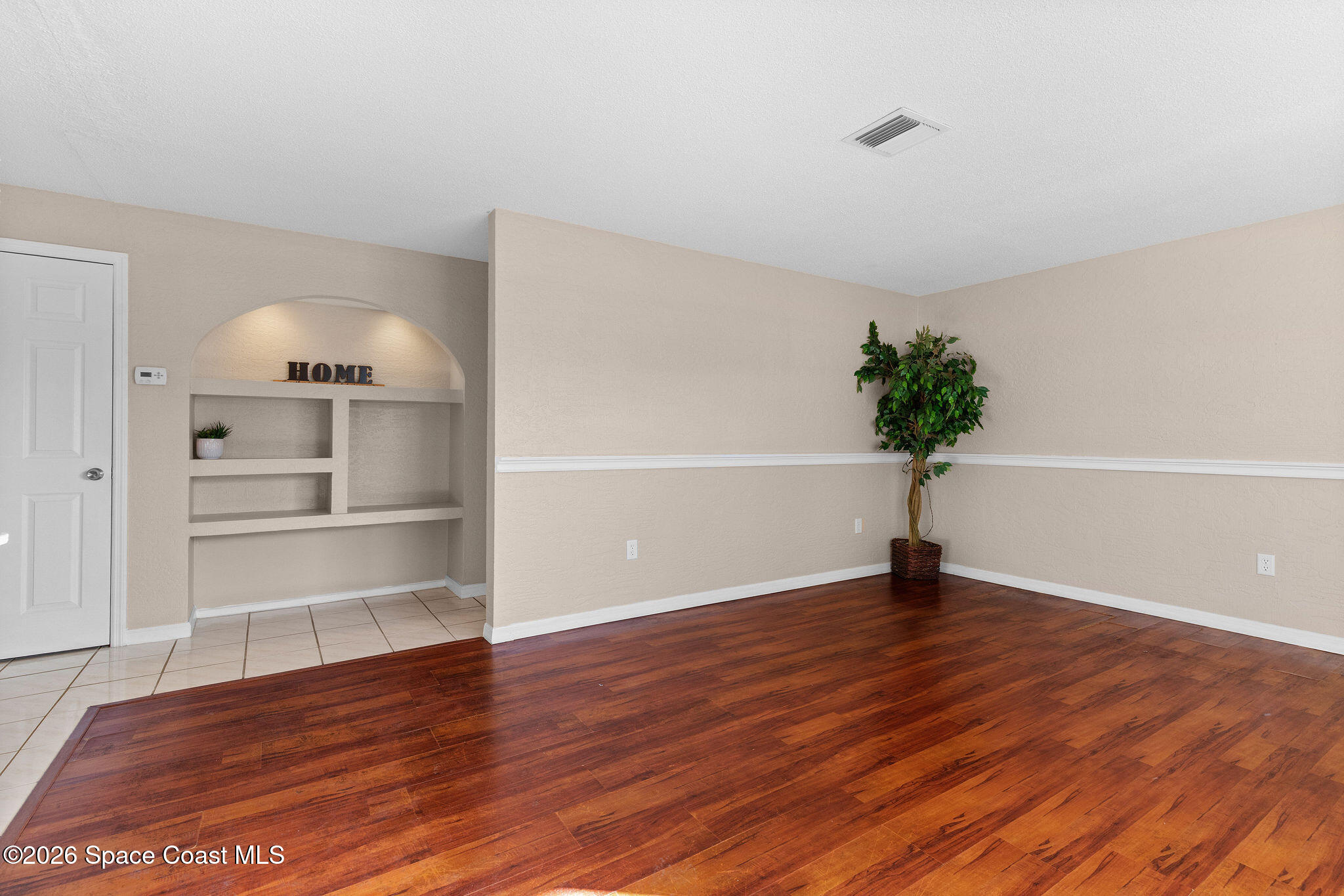 998 Kings Post Road Rockledge, FL 32955 - Photo 14 of 39 a view of an empty room with a window and wooden floor