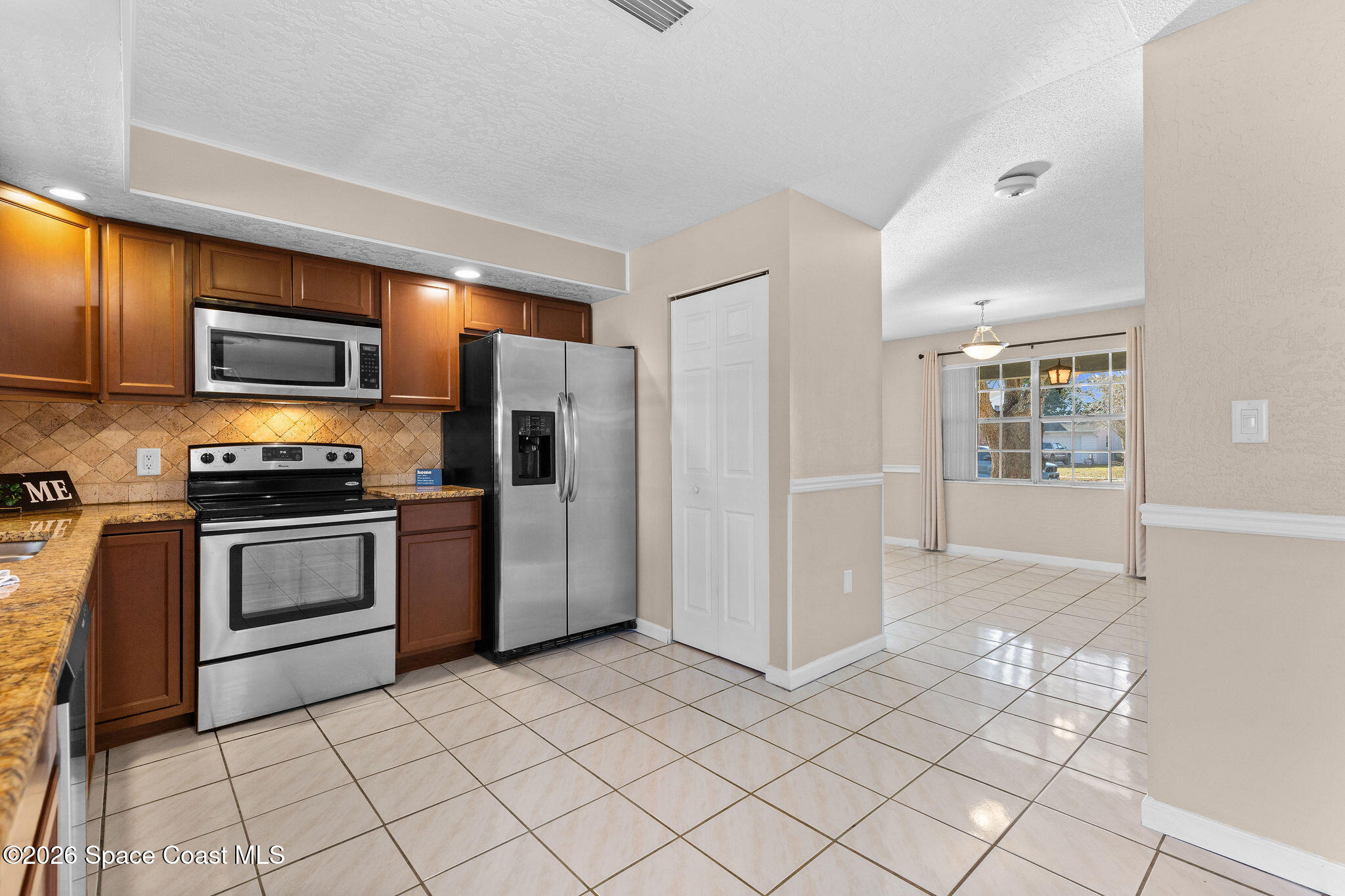 998 Kings Post Road Rockledge, FL 32955 - Photo 26 of 39 a kitchen with stainless steel appliances a refrigerator and a stove top oven