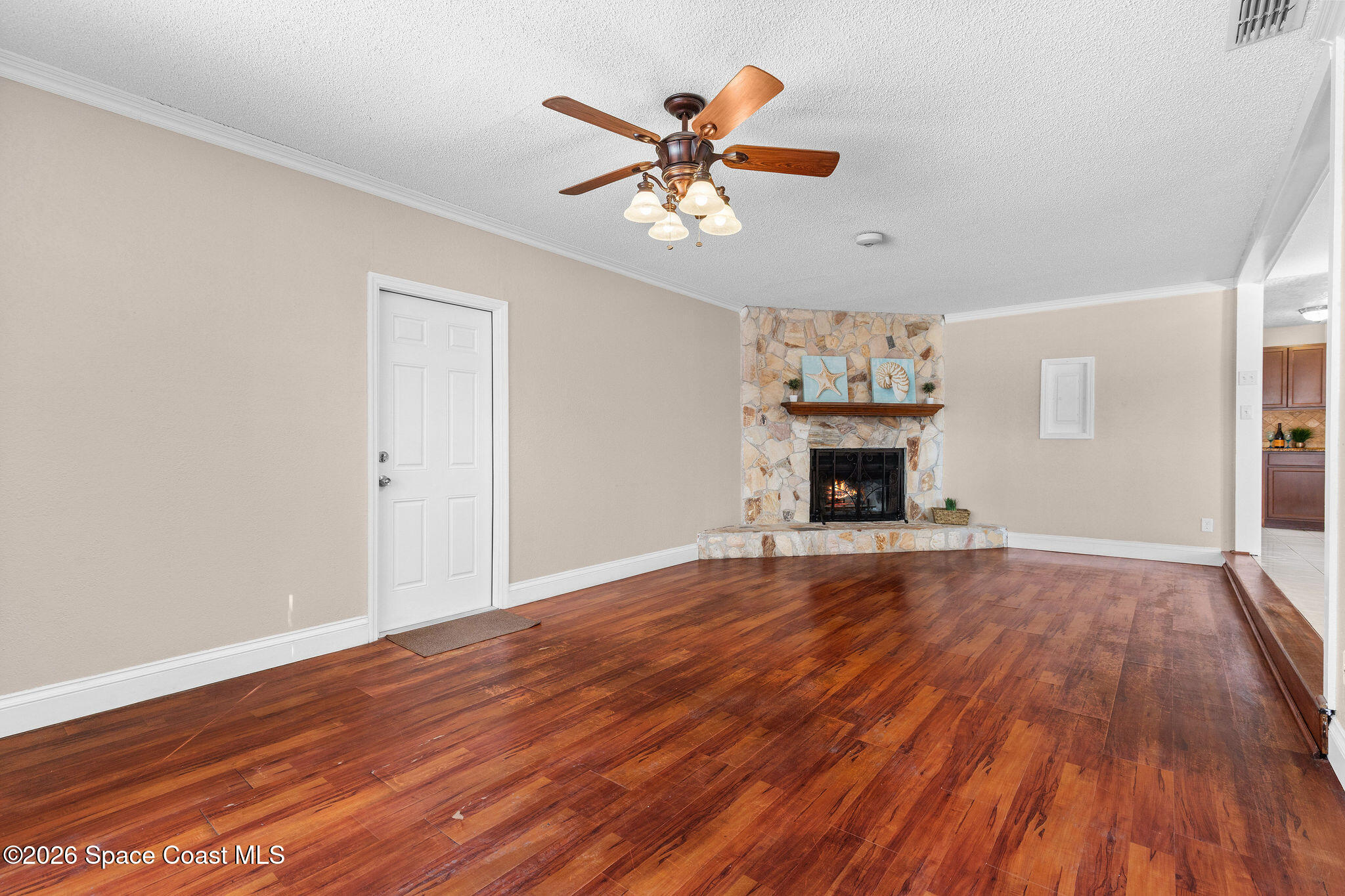 998 Kings Post Road Rockledge, FL 32955 - Photo 29 of 39 a view of an empty room with wooden floor and a fireplace