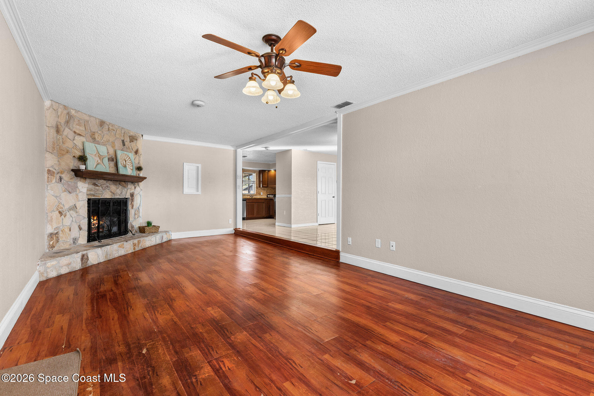 998 Kings Post Road Rockledge, FL 32955 - Photo 30 of 39 a view of an empty room with wooden floor and a fireplace