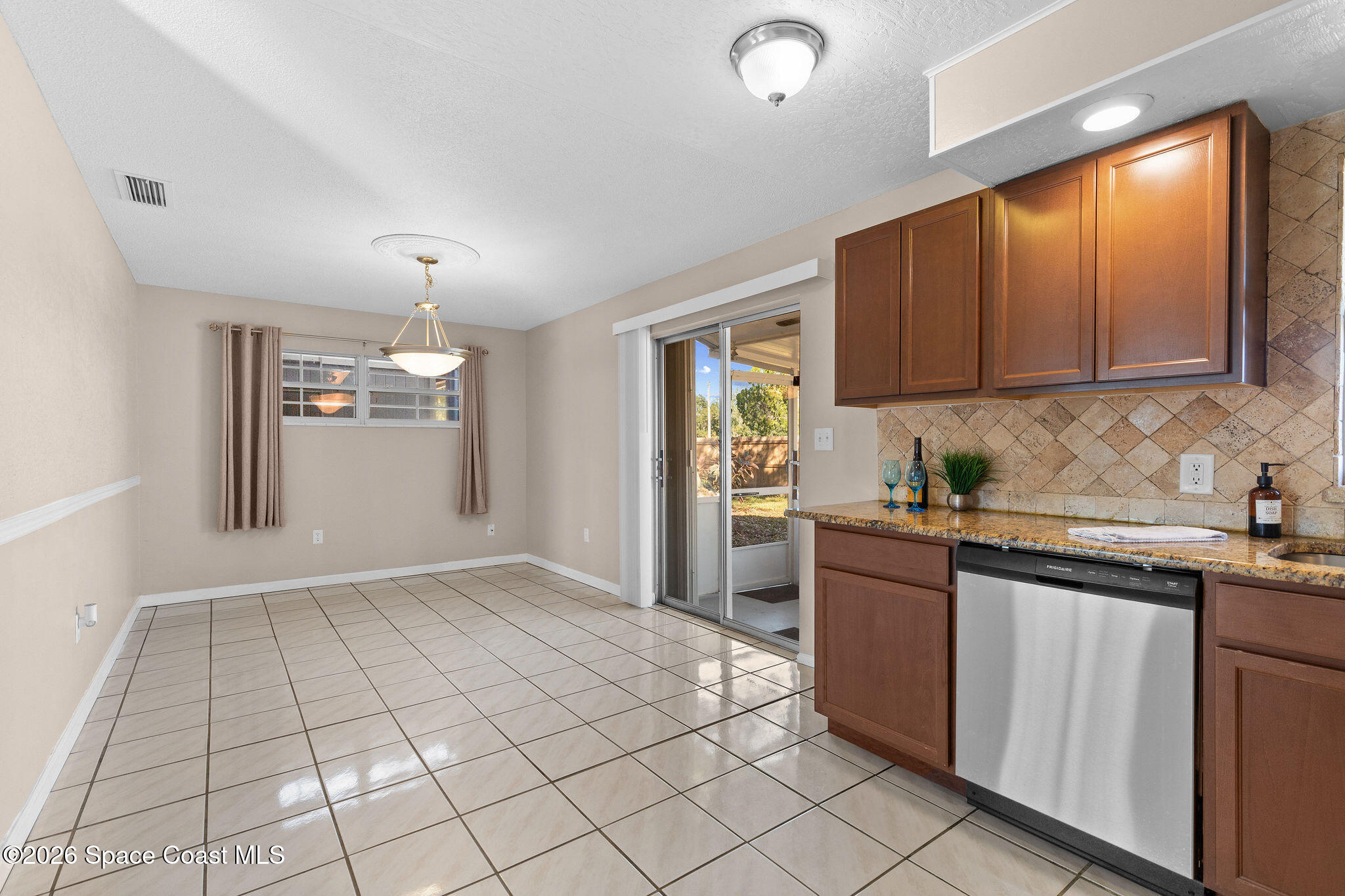 998 Kings Post Road Rockledge, FL 32955 - Photo 9 of 39 a kitchen with stainless steel appliances granite countertop a refrigerator sink and cabinets