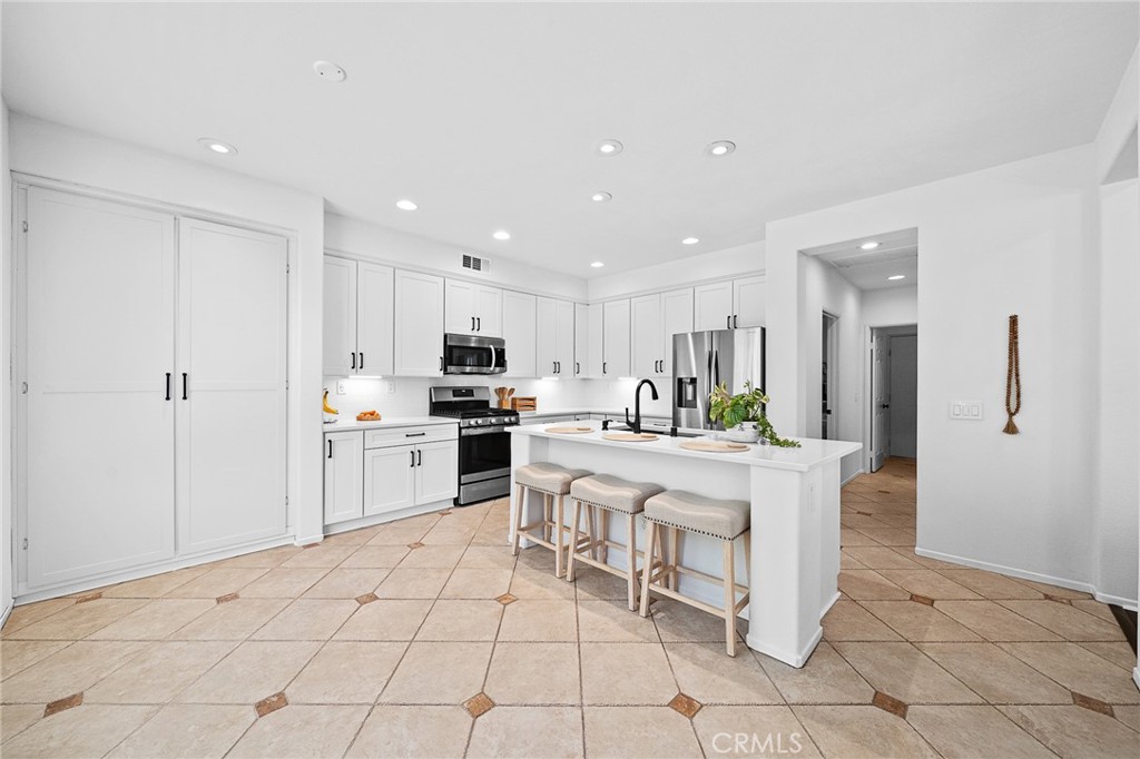 29027 Raintree Lane Saugus, CA 91390 - Photo 18 of 45 a kitchen with white cabinets and stainless steel appliances
