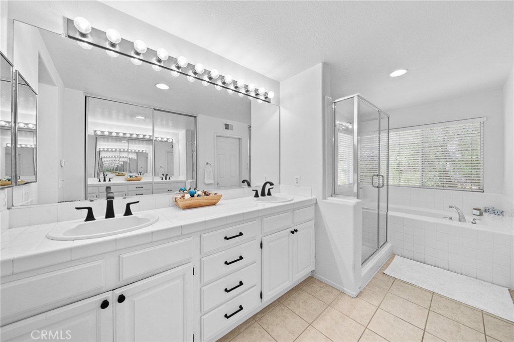29027 Raintree Lane Saugus, CA 91390 - Photo 31 of 45 a bathroom with double vanity sink a mirror and a bathtub