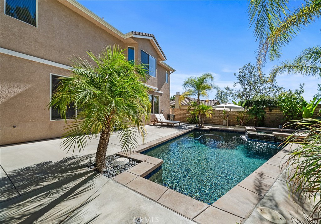 29027 Raintree Lane Saugus, CA 91390 - Photo 37 of 45 a view of a backyard with couches plants and palm trees