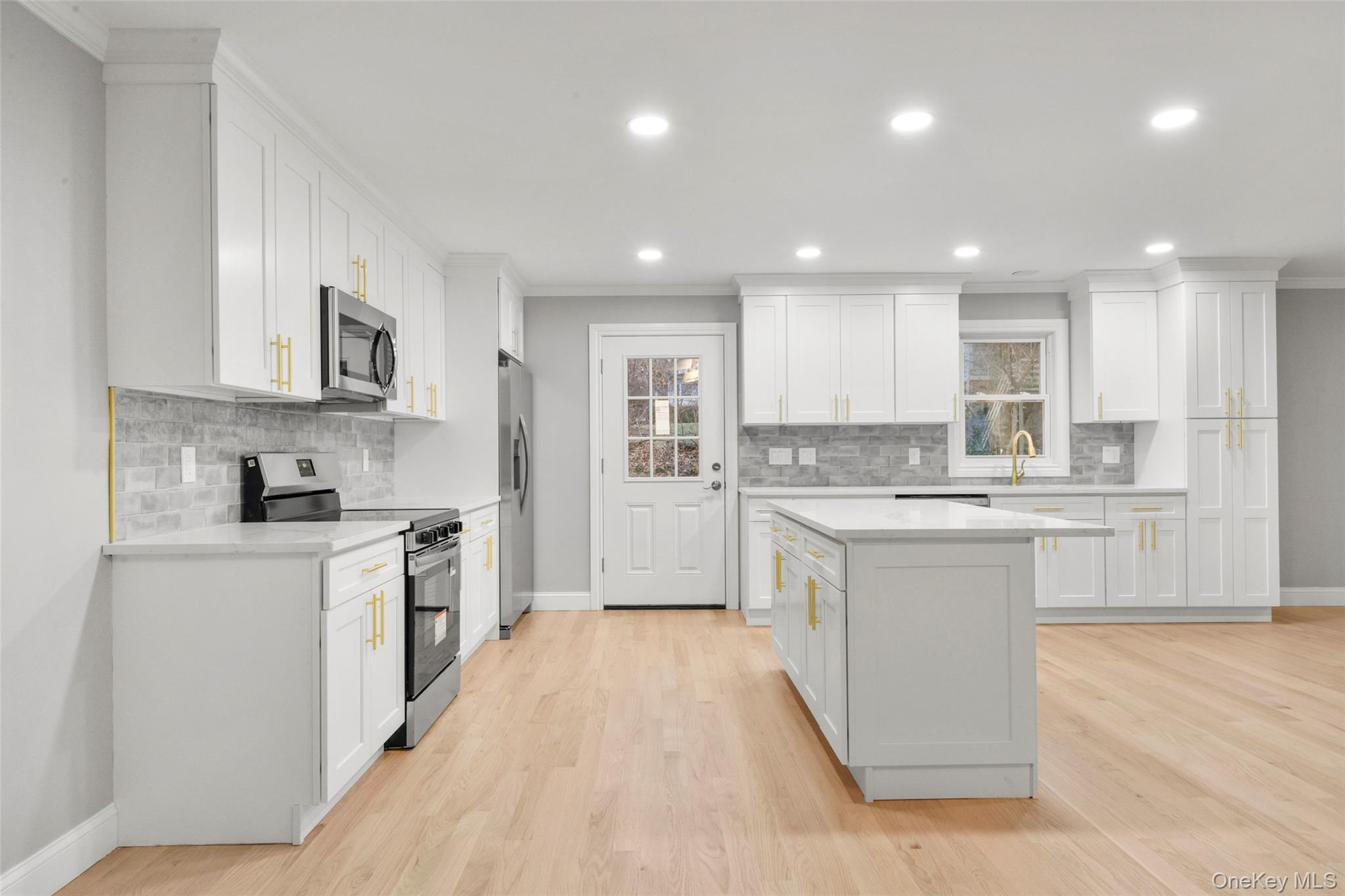 26 Ashton Road Yonkers, NY 10705 - Photo 5 of 33 a large kitchen with stainless steel appliances granite countertop a stove top oven a sink and white cabinets