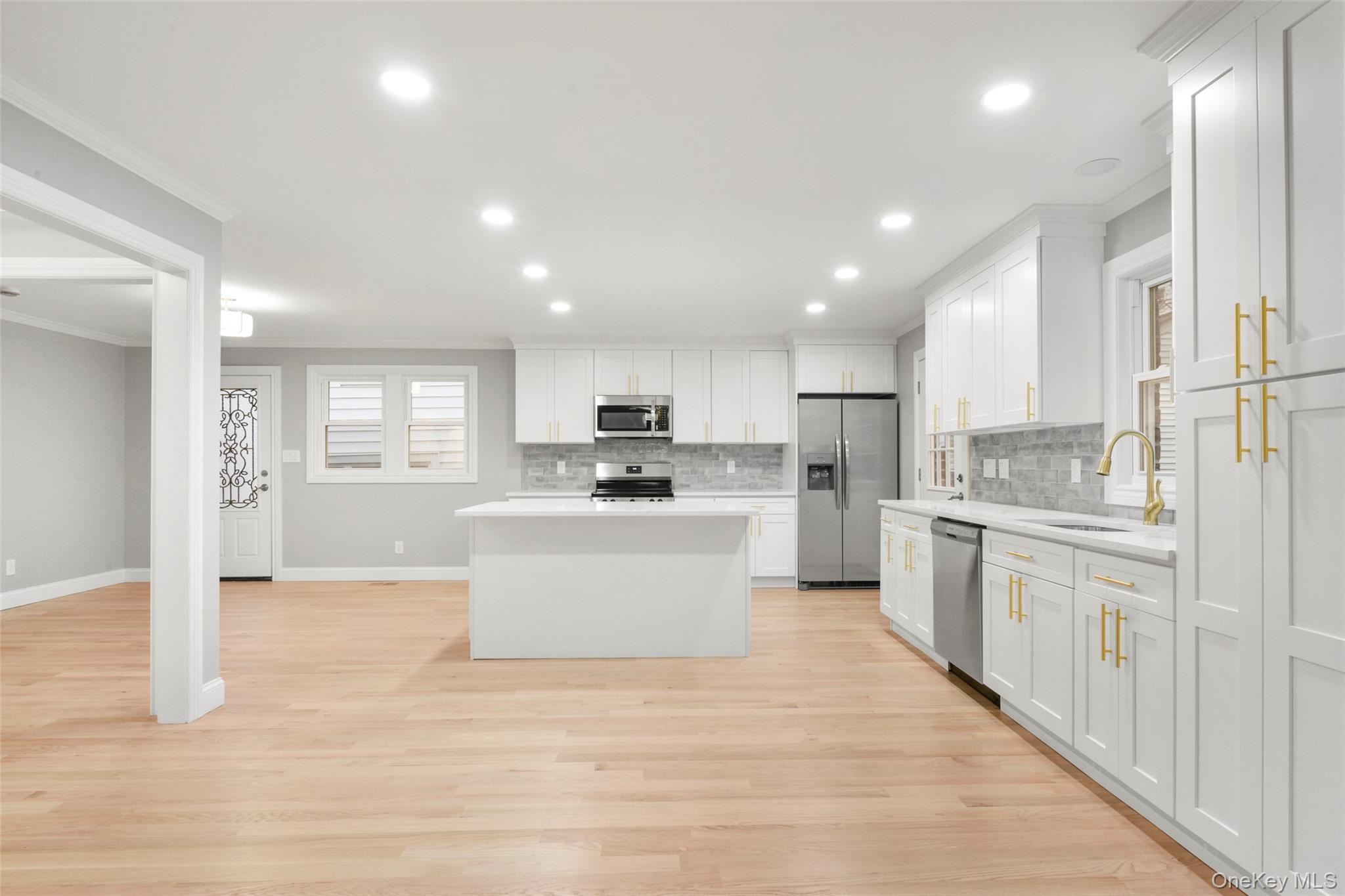 26 Ashton Road Yonkers, NY 10705 - Photo 6 of 33 a large kitchen with kitchen island a sink a stove a refrigerator and white cabinets