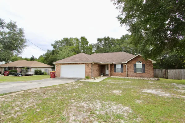 a front view of a house with a yard and trees