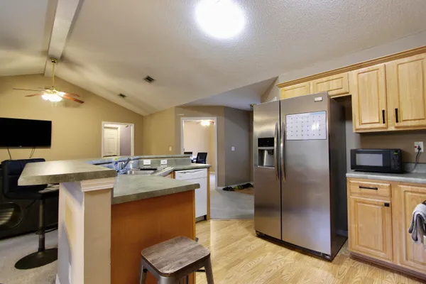 a kitchen with kitchen island granite countertop a stove refrigerator and cabinets
